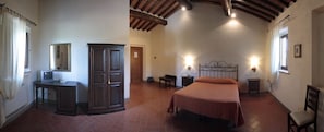 A bedroom with a bed, a desk, a wardrobe, and a mirror. - Le Noci (Gaiole in Chianti)