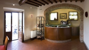 Un espace bar doté d’un comptoir incurvé, d’un meuble à vin et offrant une vue à travers une arche.