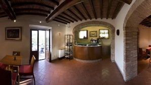 Un restaurant doté d’un bar, de tables et d’une vue dégagée sur l’extérieur, accessible par une arche.