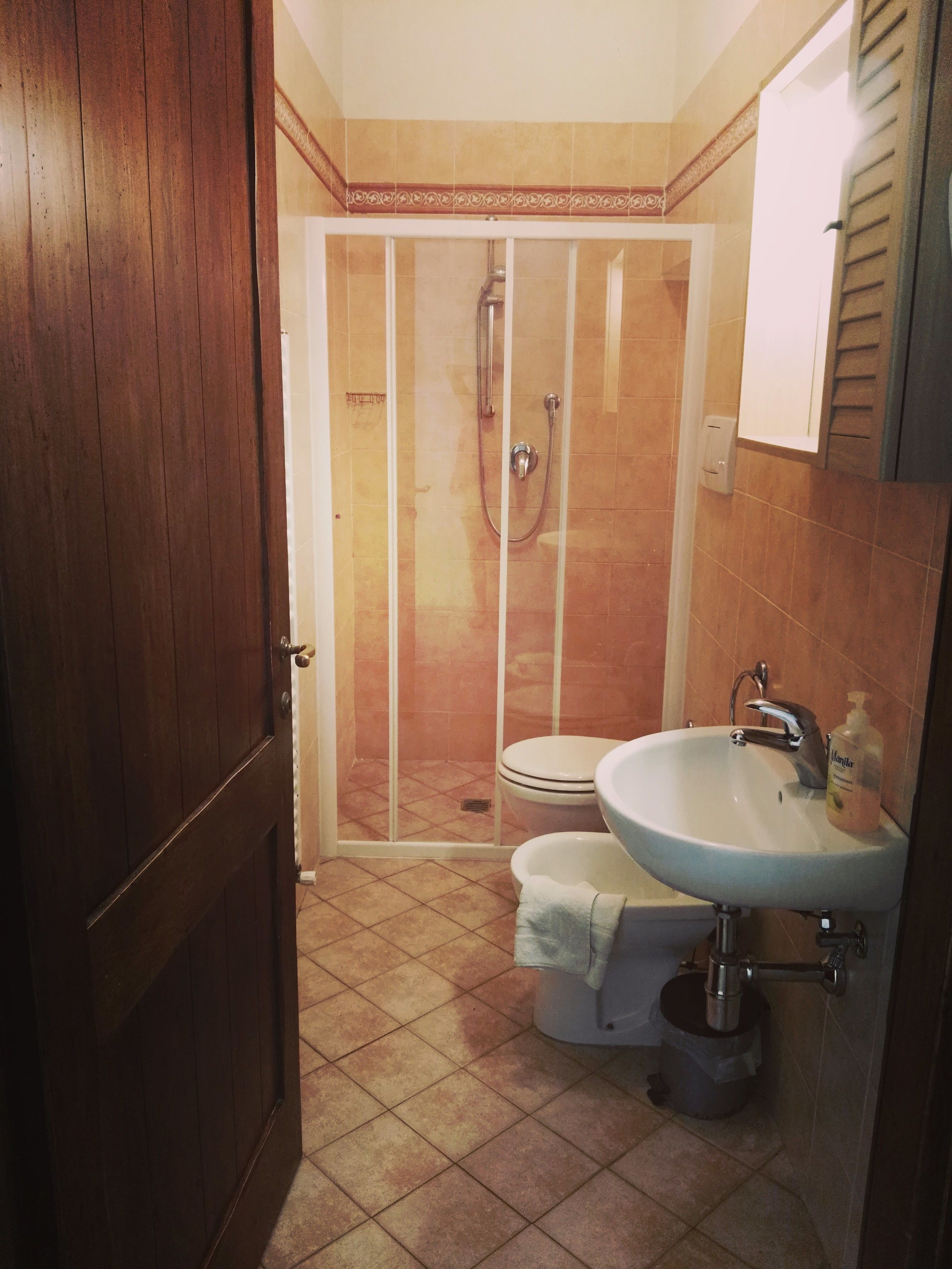 A bathroom with a shower, toilet, and sink.