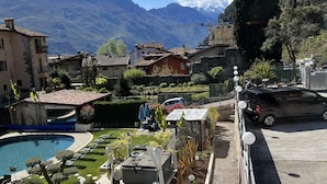 A residential area with a swimming pool, garden, and mountain views.