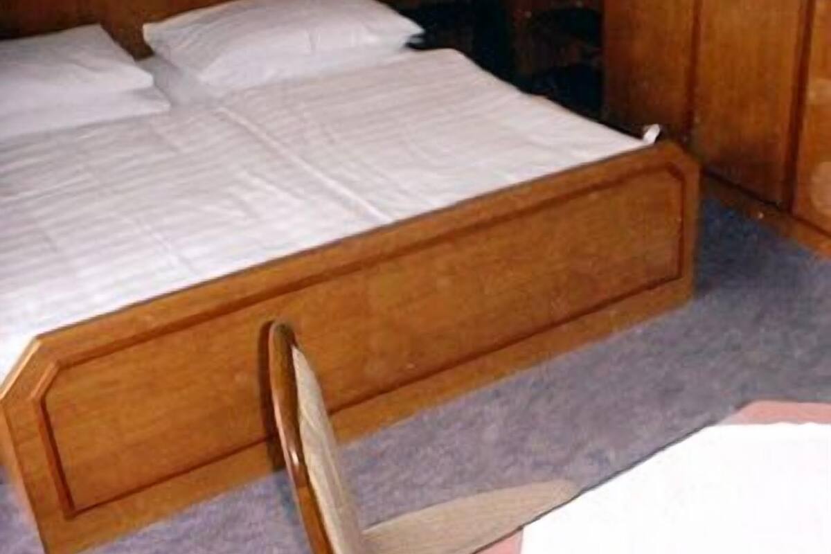 A bedroom with a wooden bed, a nightstand, and a dresser.