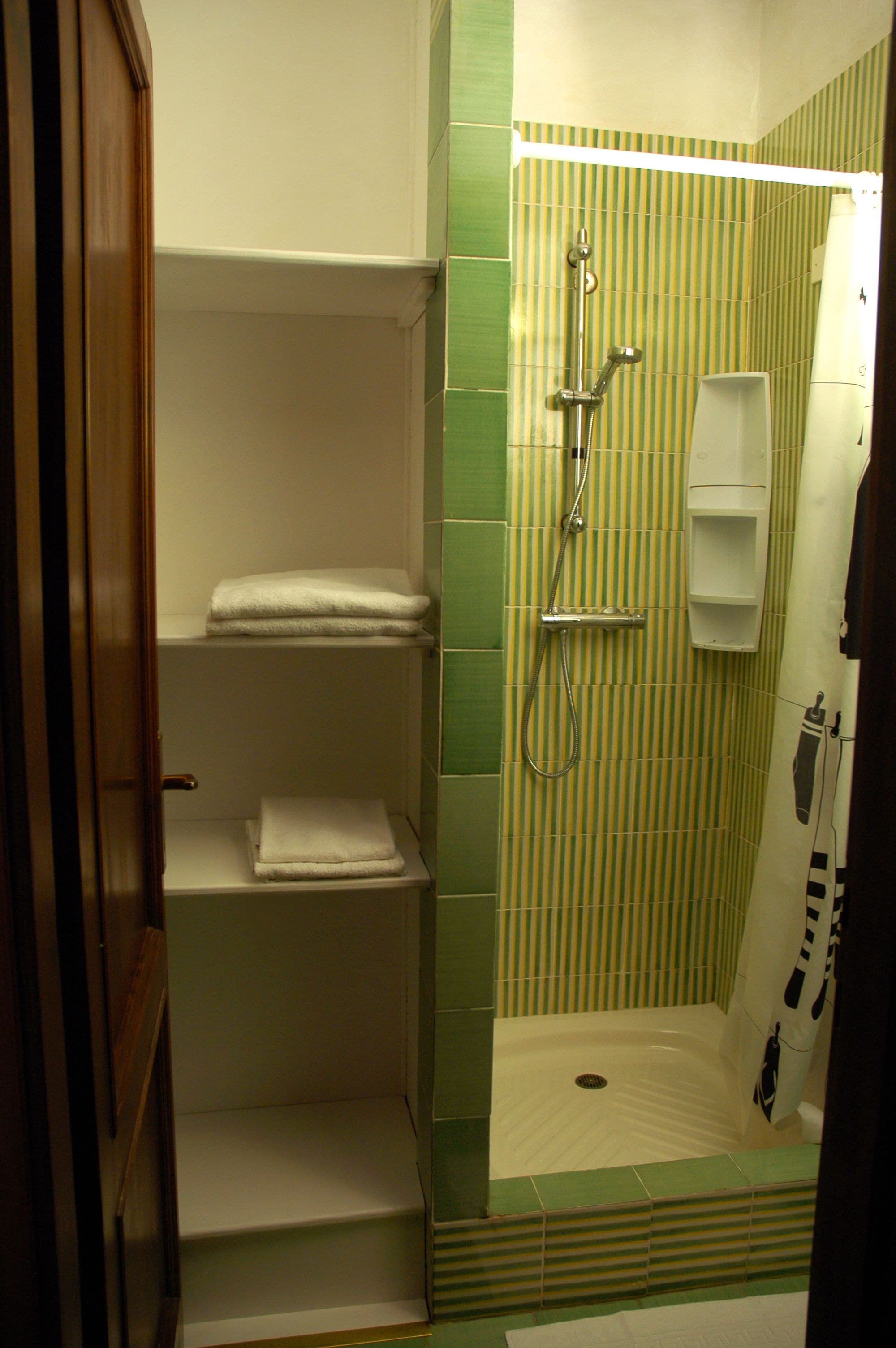 A bathroom with a shower, a towel rack, and a toilet.