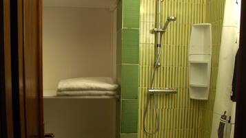 Un baño con ducha, perchero y retrete.