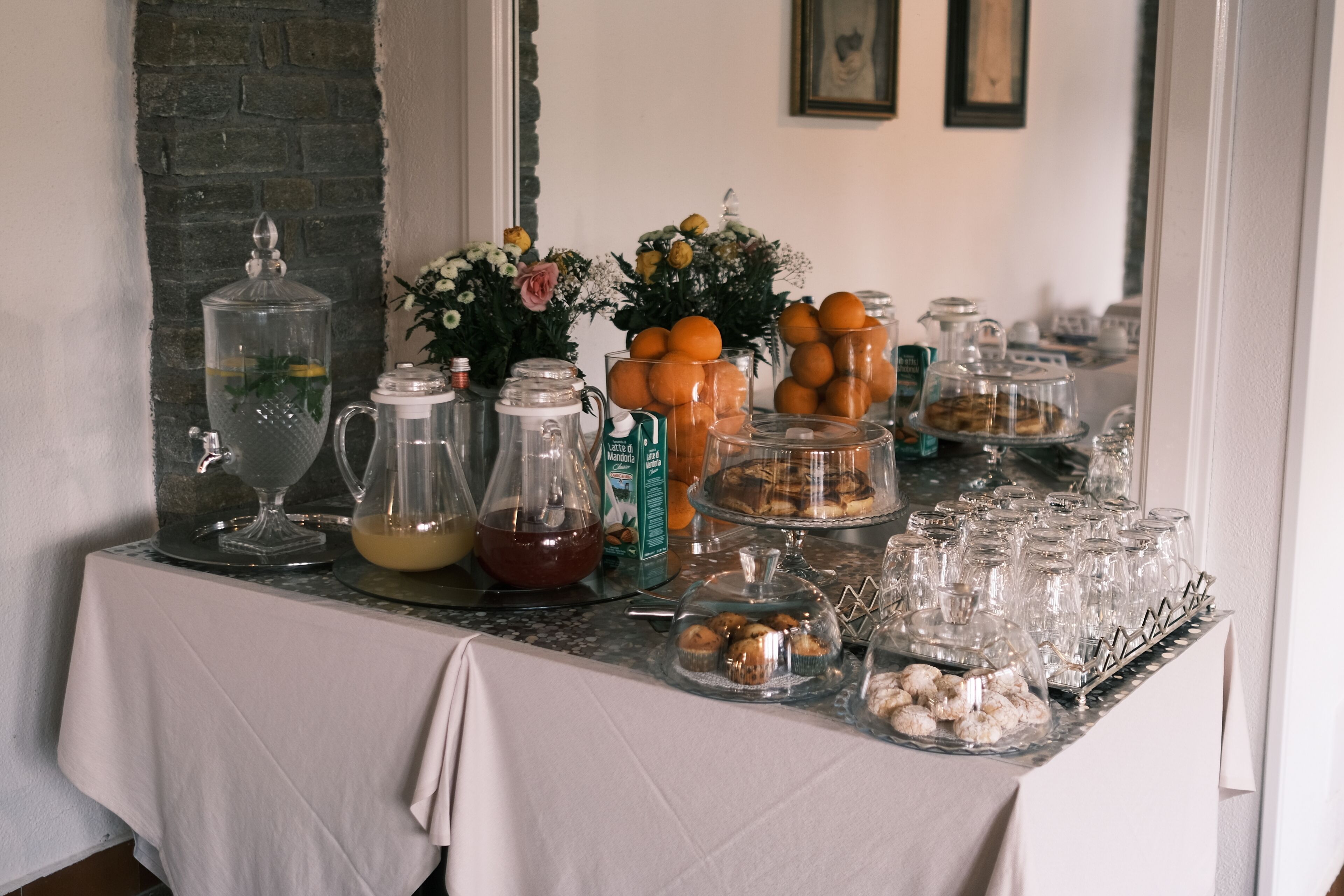 A buffet table with various food items, beverages, and decorative elements.