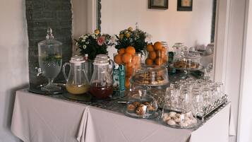Una mesa de buffet con diferentes alimentos, bebidas y elementos decorativos.