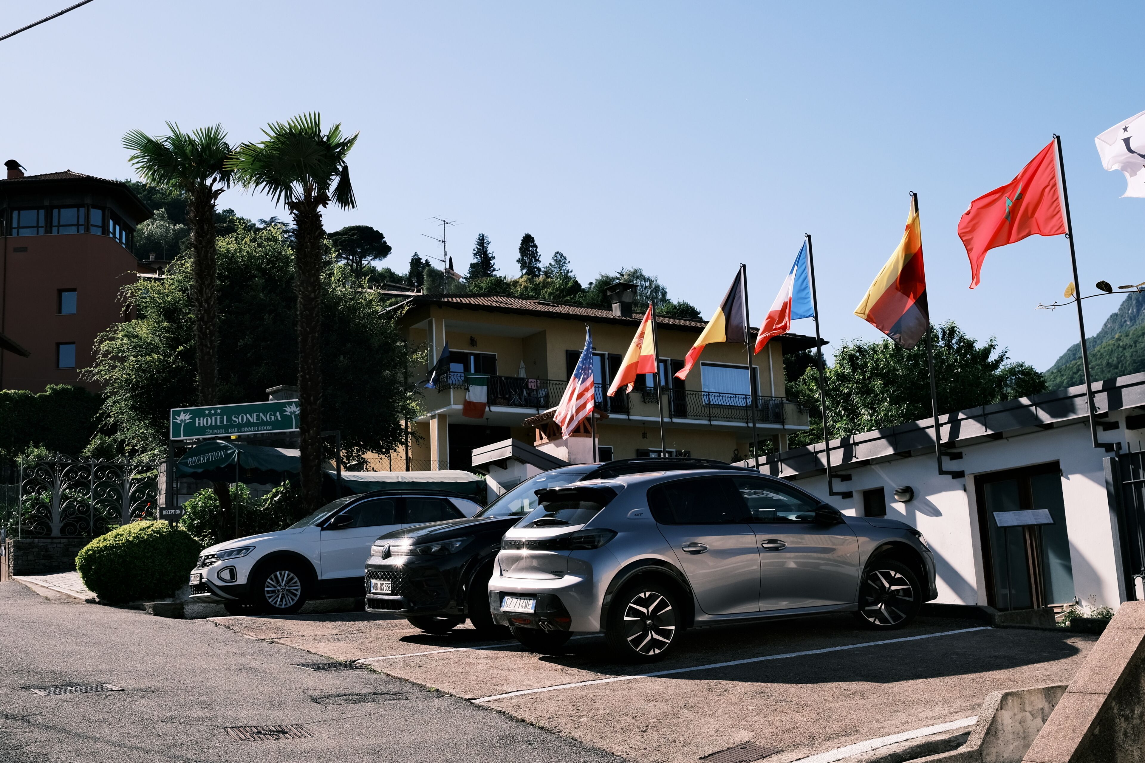 Un hôtel doté d’un hall d’accueil, d’un parking et de plusieurs drapeaux.