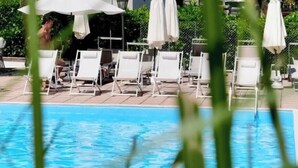A swimming pool with lounge chairs and umbrellas. - Hotel Sonenga (Menaggio)