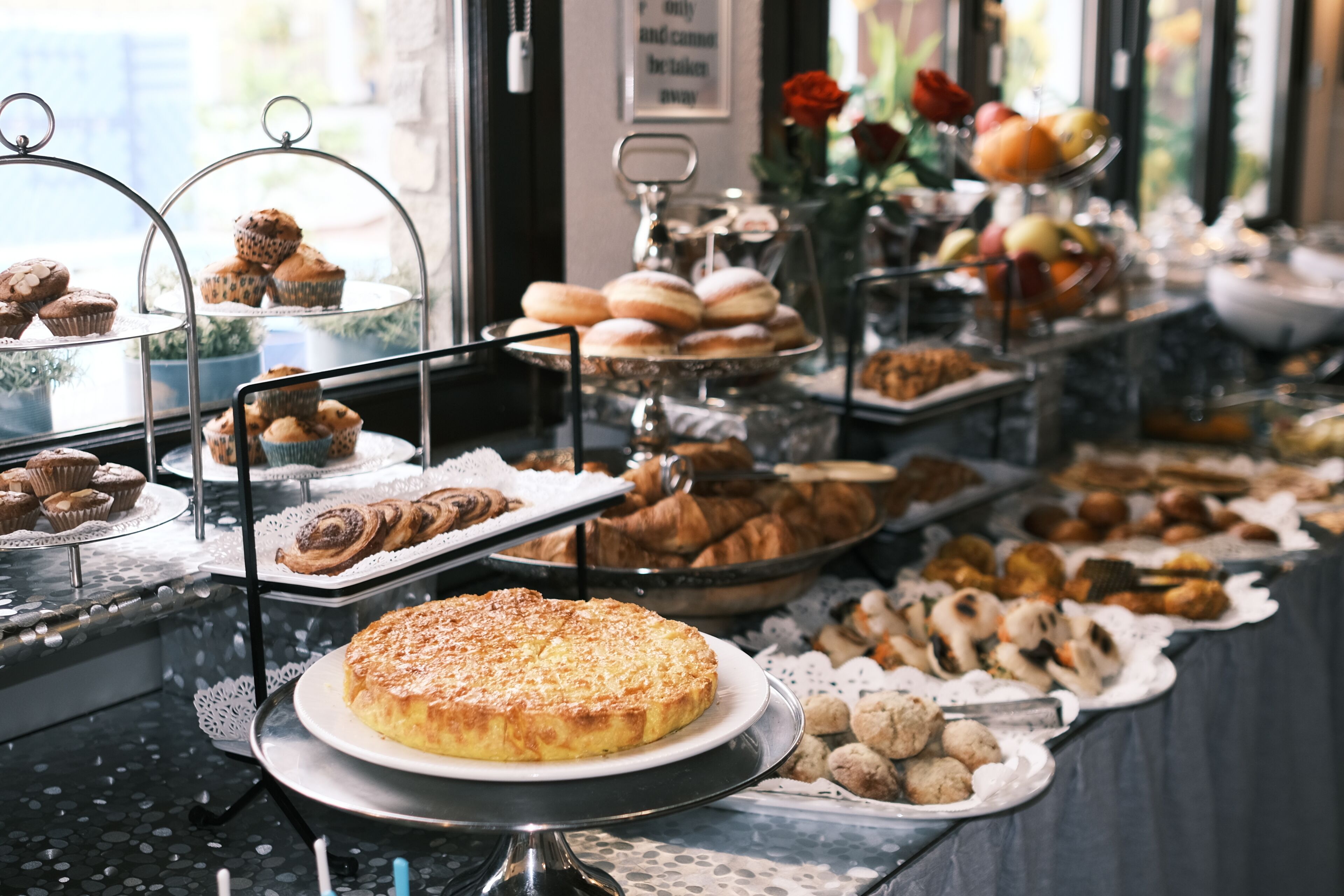Un buffet proposant une variété de produits de boulangerie et de pâtisserie.