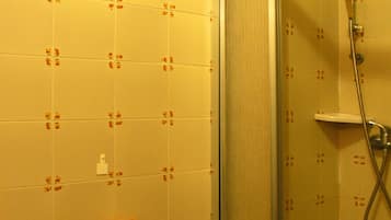 A bathroom with a shower, toilet, and bidet.