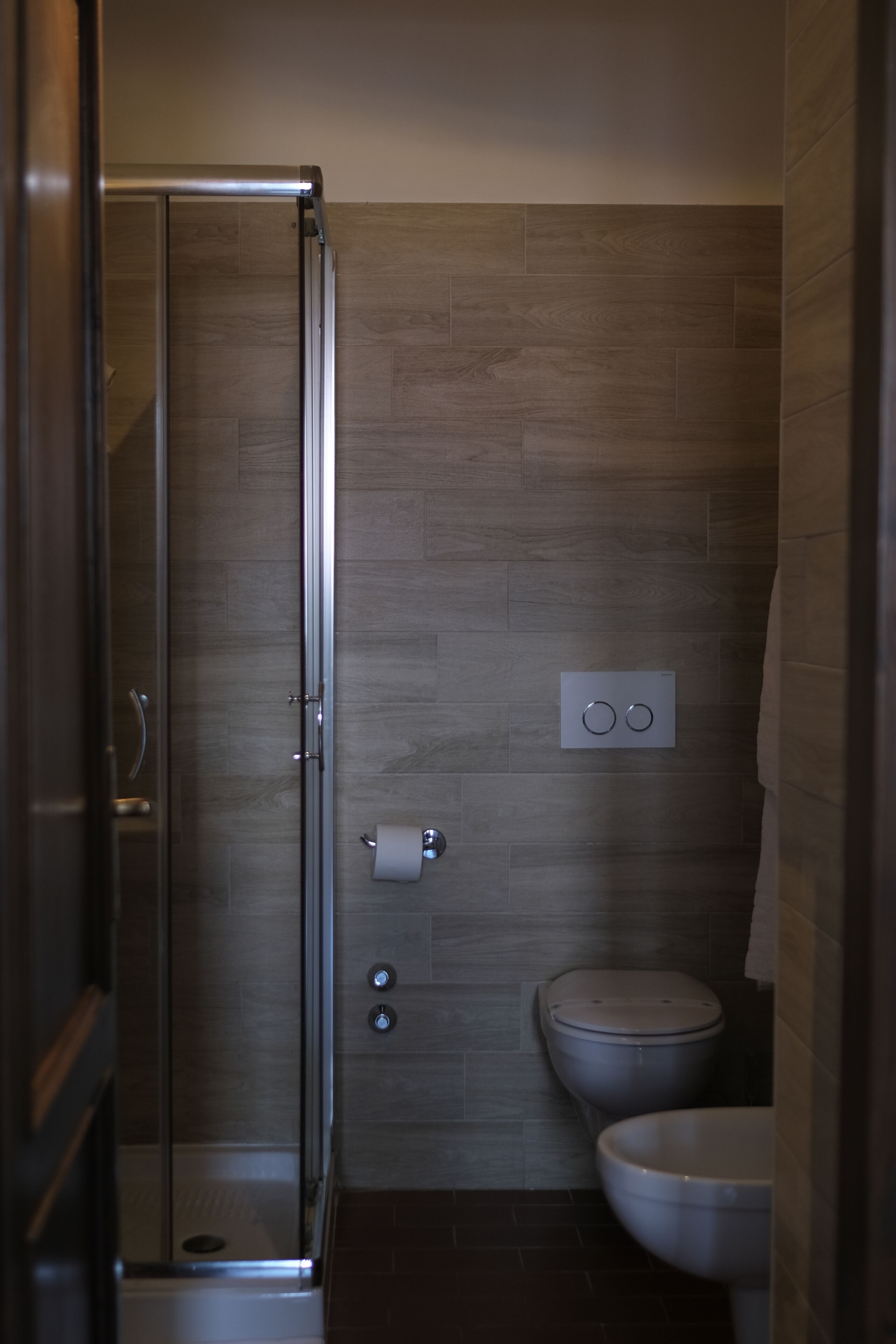 Un baño con cabina de ducha de vidrio, inodoro y bidé.