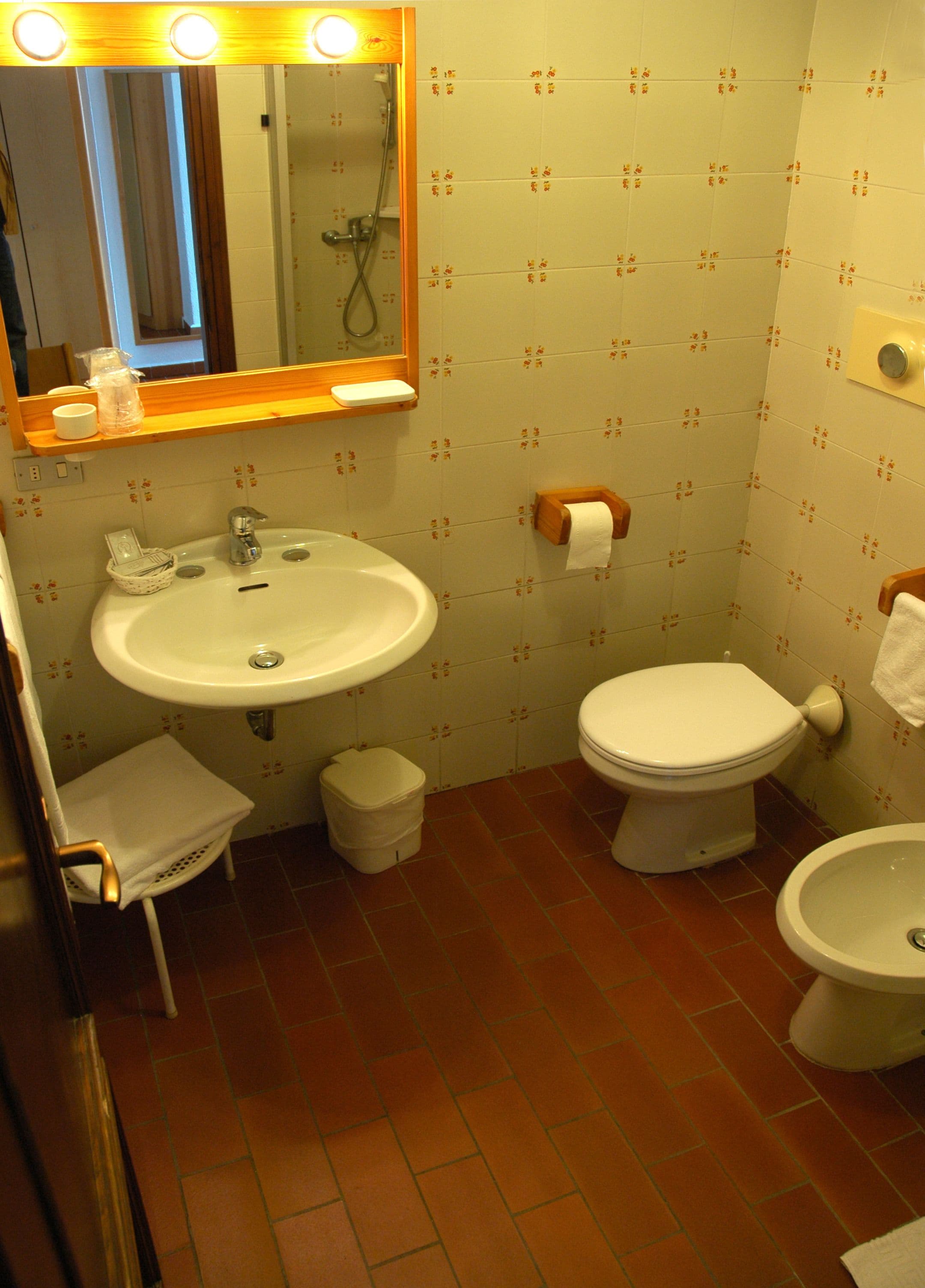Un baño pequeño con lavamanos, inodoro y bidé.