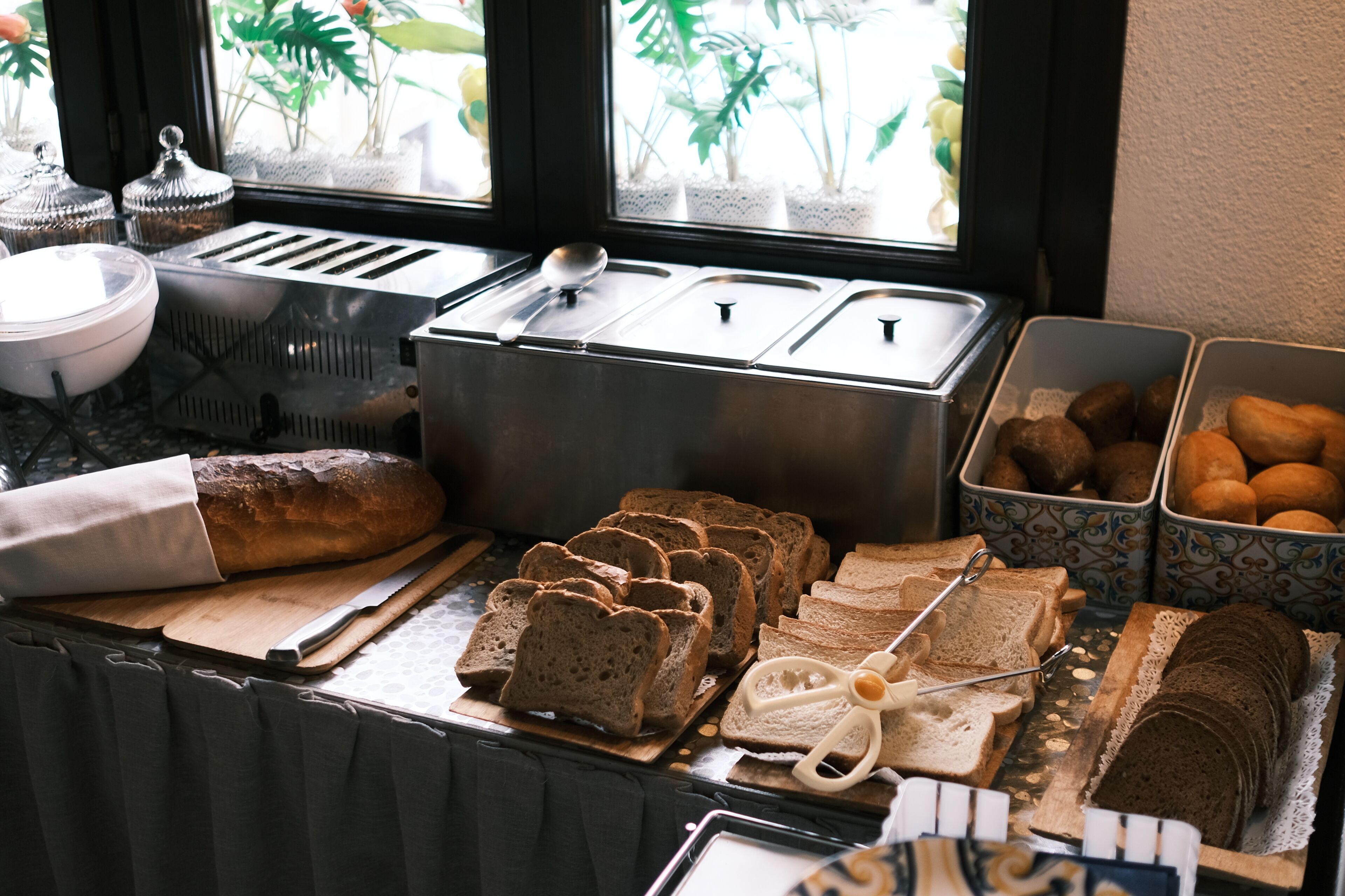 Un buffet de petit-déjeuner comprenant du pain, des viennoiseries et un grille-pain.