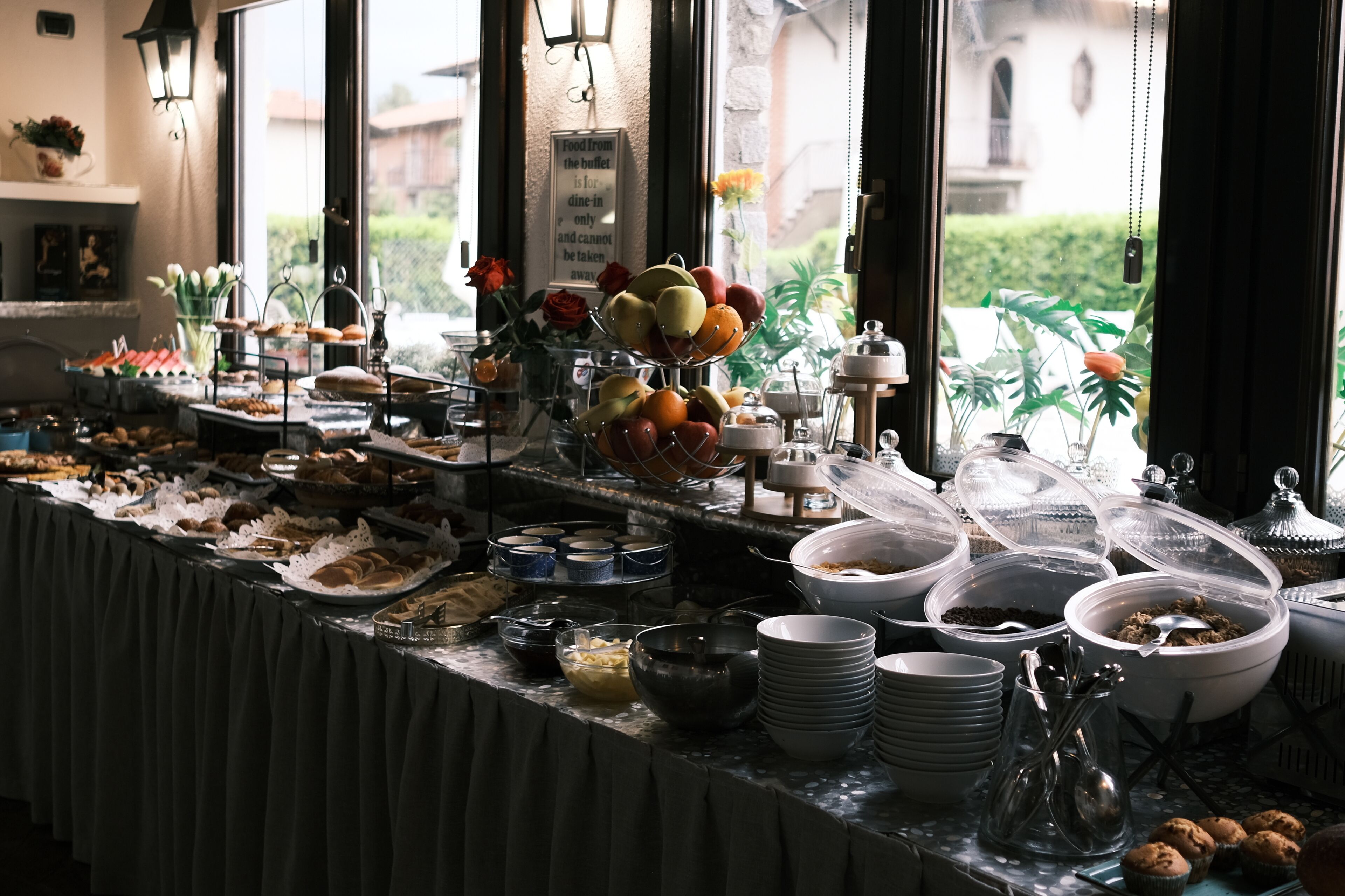 Un'area buffet con diversi cibi e un cartello che indica che il cibo è riservato al consumo all'interno.