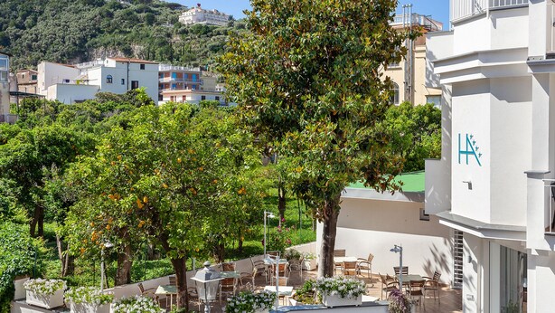 Un hotel con terraza al aire libre, una escalera y vistas del entorno.
