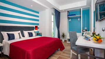 Una habitación de hotel moderna con una cama, un escritorio y vistas al exterior.