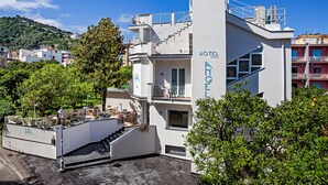 Un hotel moderno con fachada blanca, balcones y una escalera que lleva a la entrada.
