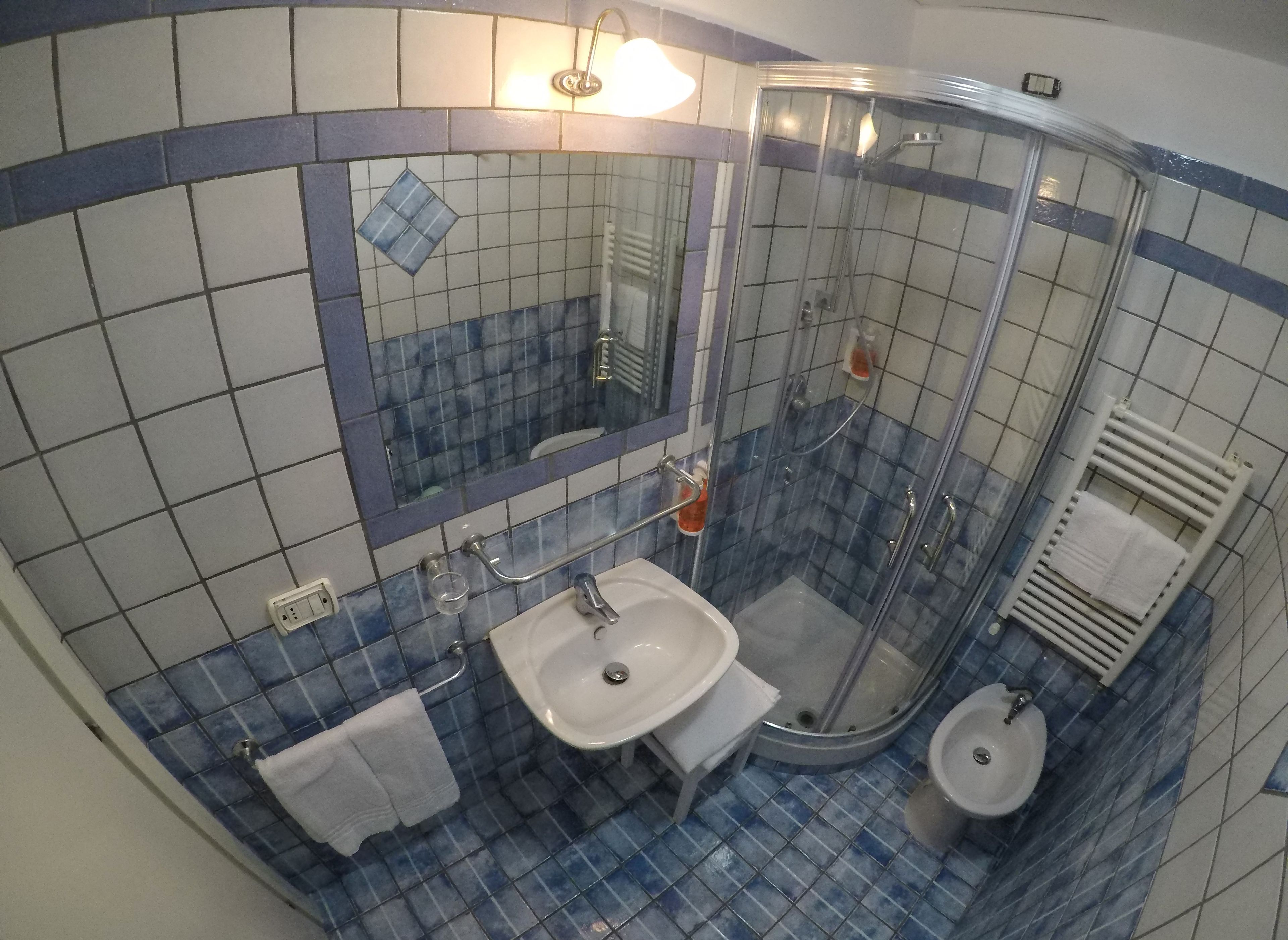 Un bagno con lavandino, specchio e doccia.