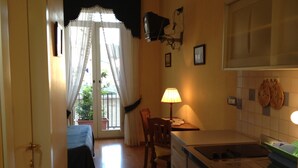 Una cocina con una mesa de comedor, sillas, una lámpara y un lavabo.