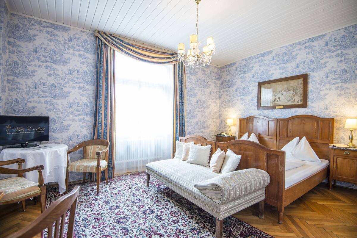 Une chambre d’hôtel équipée d’un lit, d’une télévision, d’un bureau et d’une chaise.