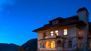 A large, historic building with a balcony and arched windows, surrounded by mountains. - Villa Excelsior Hotel Kurhaus (Bad Gastein)
