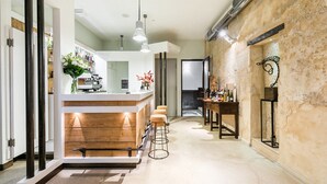 Une cuisine moderne avec un coin bar, des plans de travail en bois et des tabourets de bar.