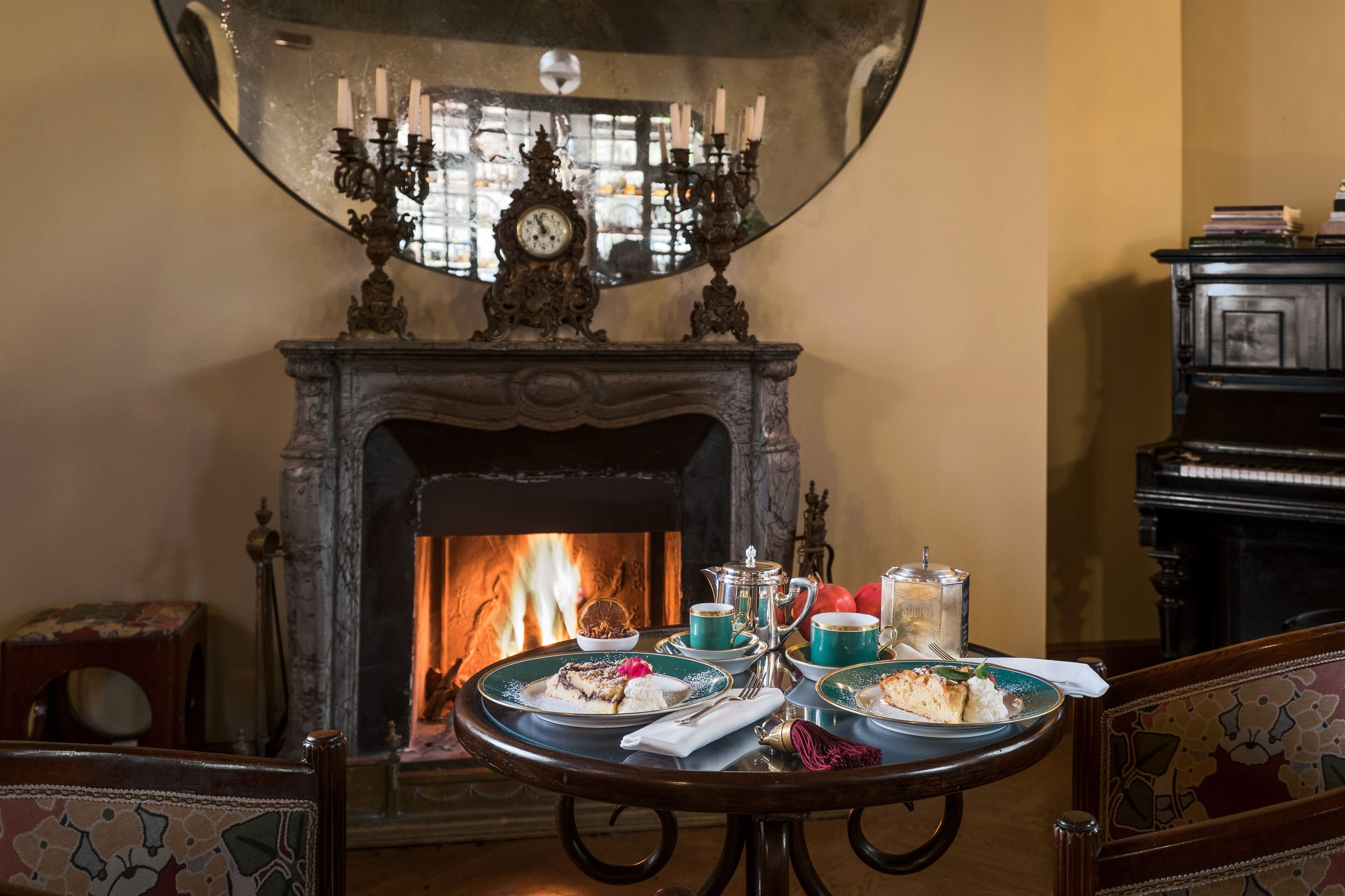Un tavolo da pranzo con piatti di cibo, un servizio da tè e un candelabro.
