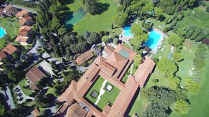 Vista aérea de una zona residencial con varias casas, una piscina y céspedes bien cuidados.