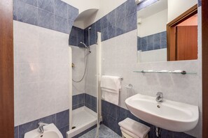 Driepersoonskamer | Badkamer | Een douche, een regendouche, gratis toiletartikelen, een haardroger