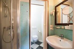 A bathroom with a glass-enclosed shower, a white toilet, and a sink with a mirror. - 3749 Ponte Chiodo Guest House (Venice)