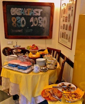 A breakfast buffet with a chalkboard sign indicating the time. - 3749 Ponte Chiodo Guest House (Venice)