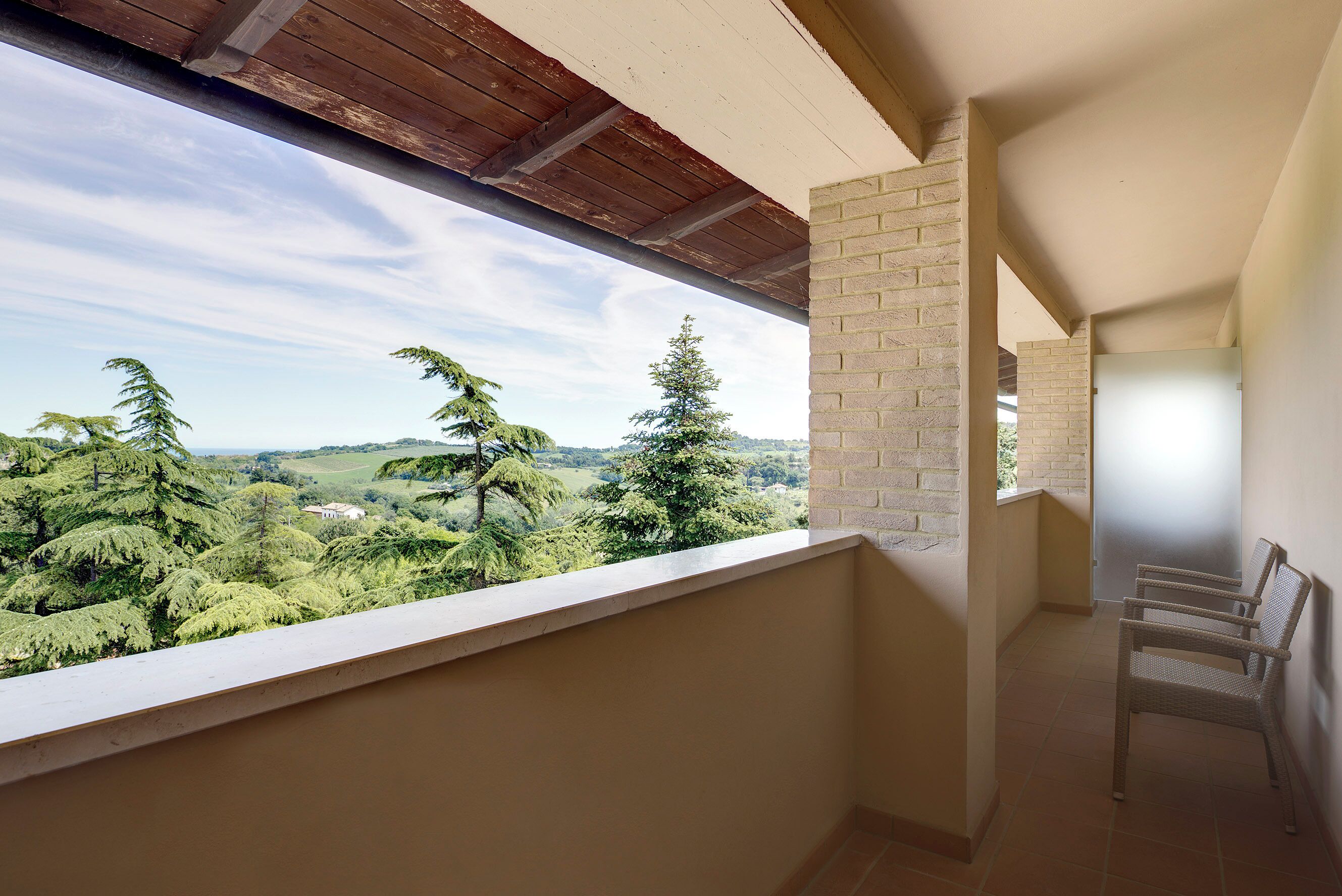 Un balcon donnant sur un paysage boisé.