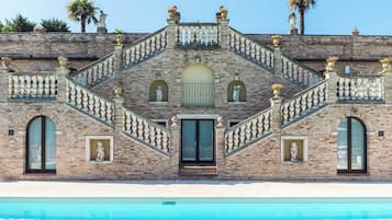 Una piscina al aire libre de temporada, sombrillas