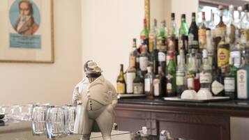A bar area with a statue of a man and a variety of liquor bottles.