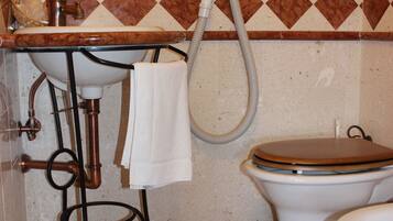 A bathroom with a checkered floor, a sink, a toilet, and a mirror.