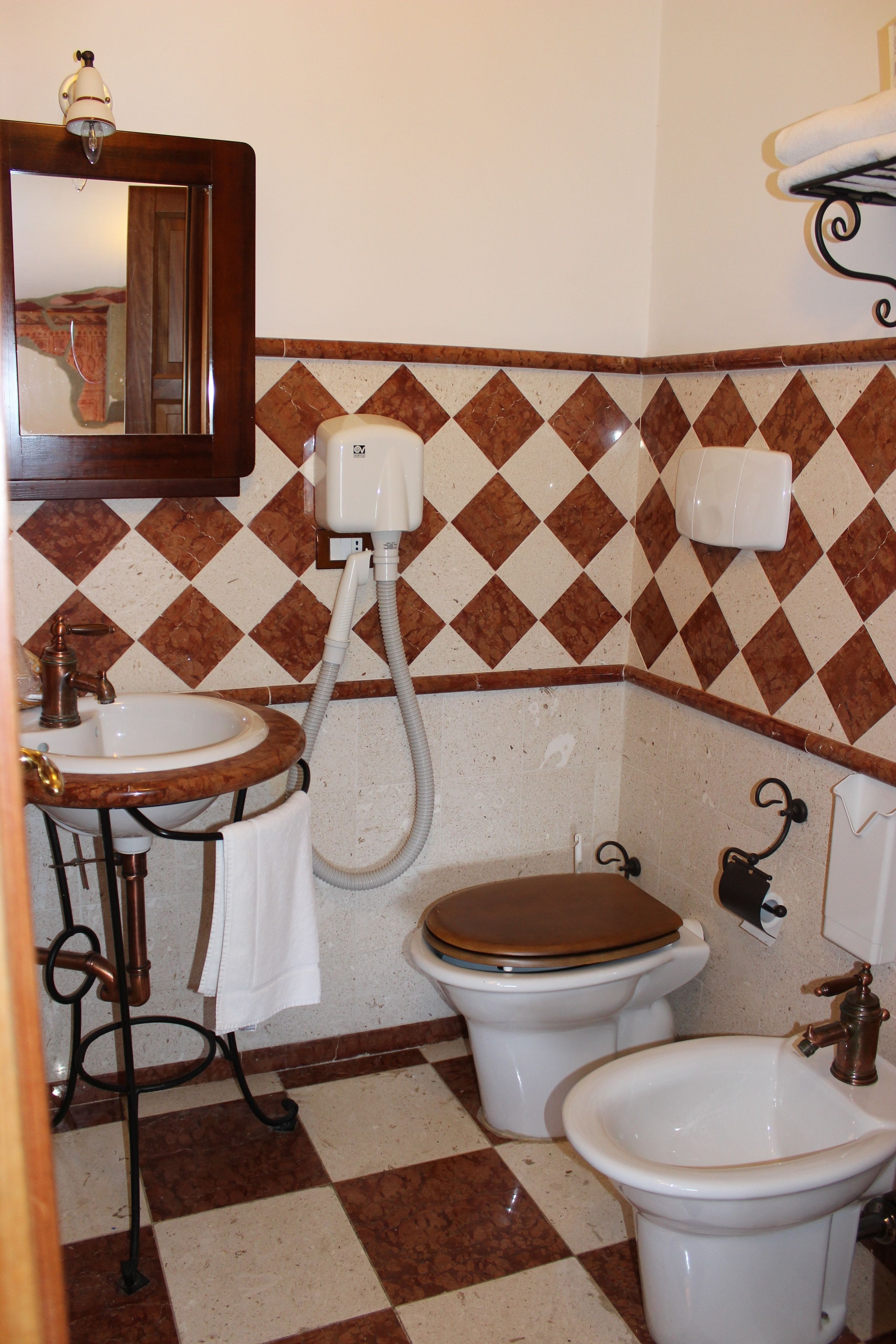 A bathroom with a sink, two toilets, and a bidet.
