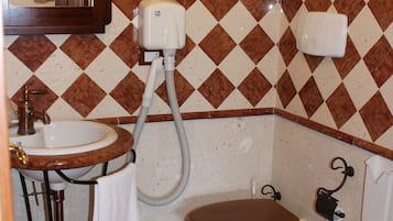 A bathroom with a sink, two toilets, and a bidet.
