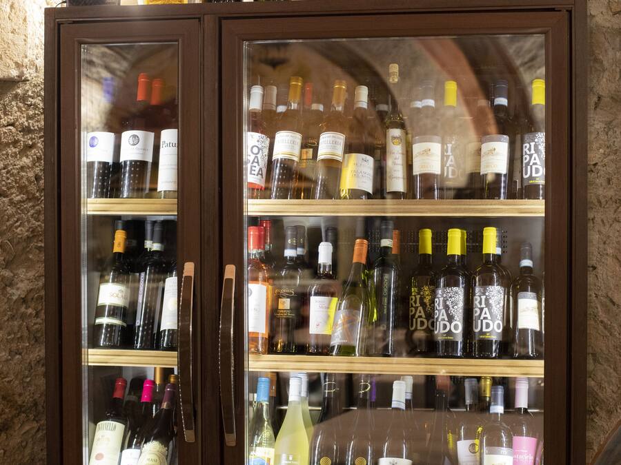 A wine cabinet with multiple shelves of various wine bottles.