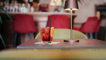 A table with a drink and a lamp.