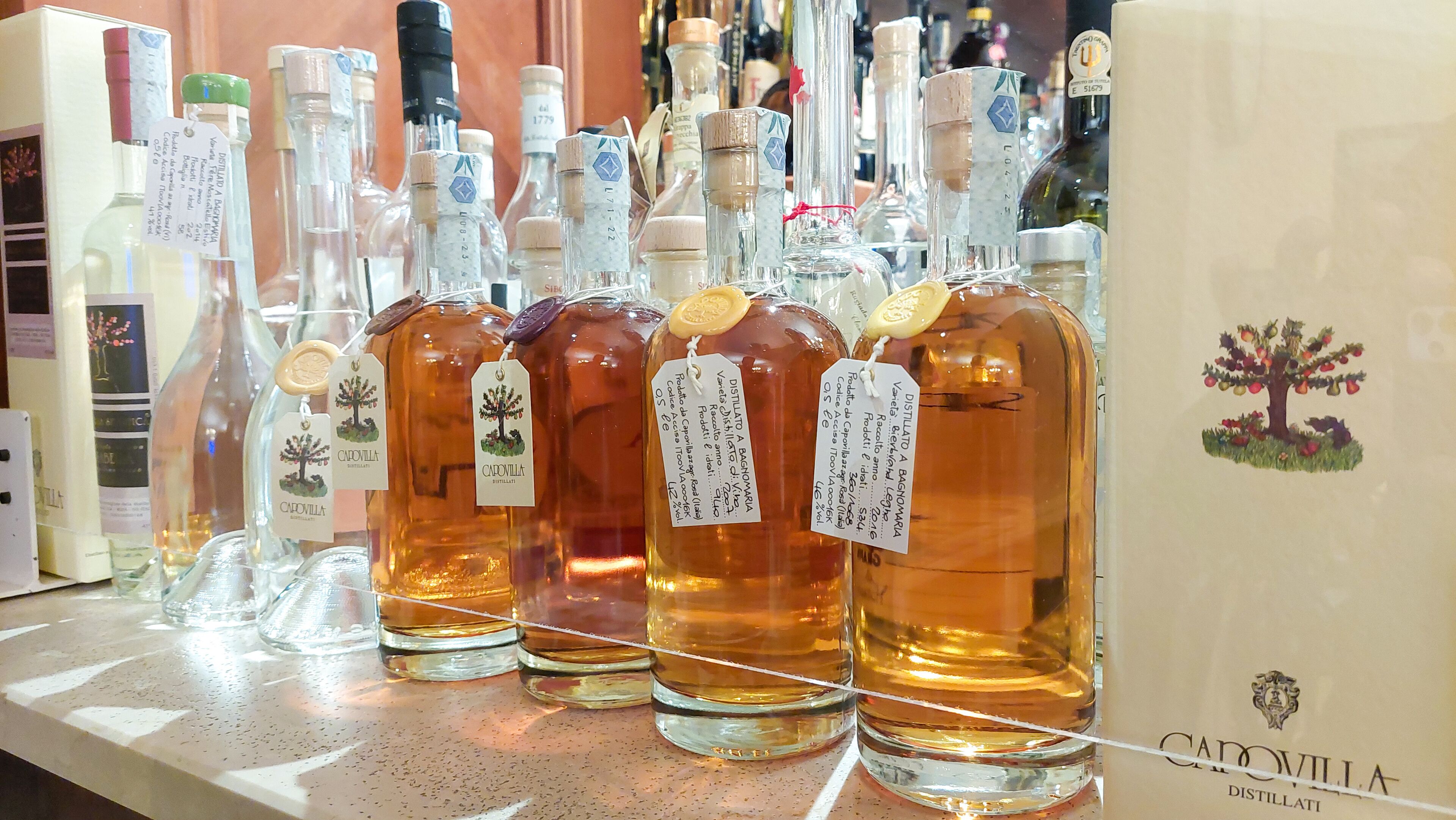 Forskellige flasker Carovilla Distillati står på en disk.