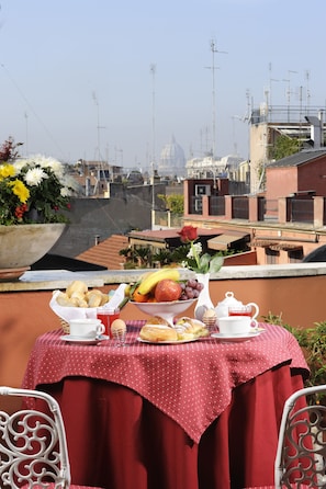A table set with breakfast items on a balcony overlooking a cityscape. - Madrid (Rome)