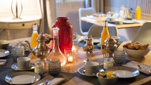 A breakfast setting with various dishes, drinks, and tableware.