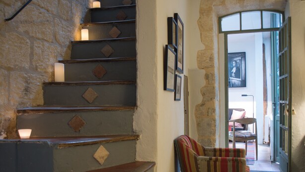 A staircase with patterned steps leading to a landing area with a cushioned seating arrangement.