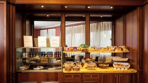 Een ontbijtbuffet met diverse etenswaren en toevoegingen, een glazen display en een houten inrichting.
