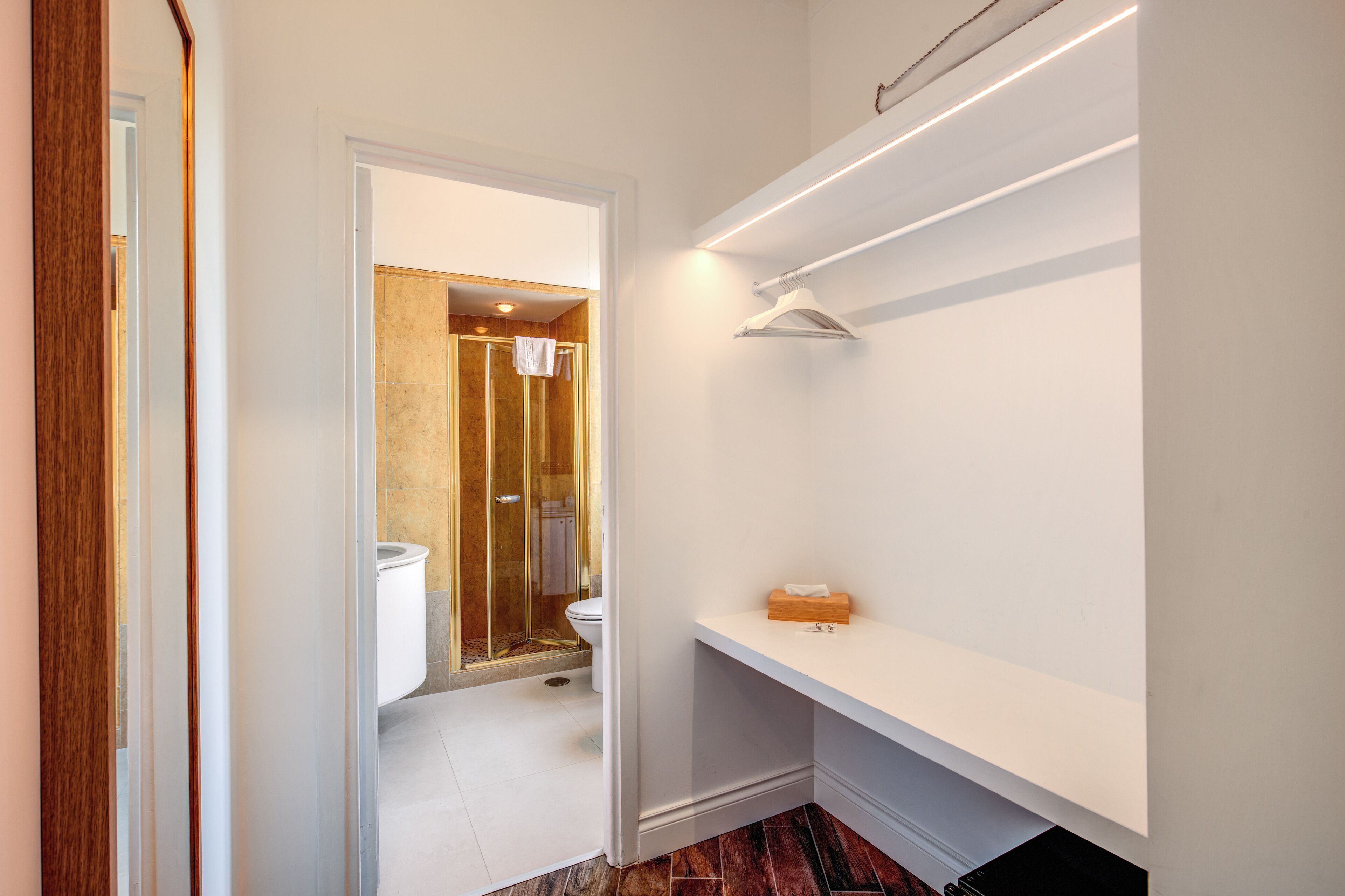 Une salle de bain moderne équipée d’une douche, de toilettes et d’un meuble-lavabo avec un miroir et un porte-serviettes.