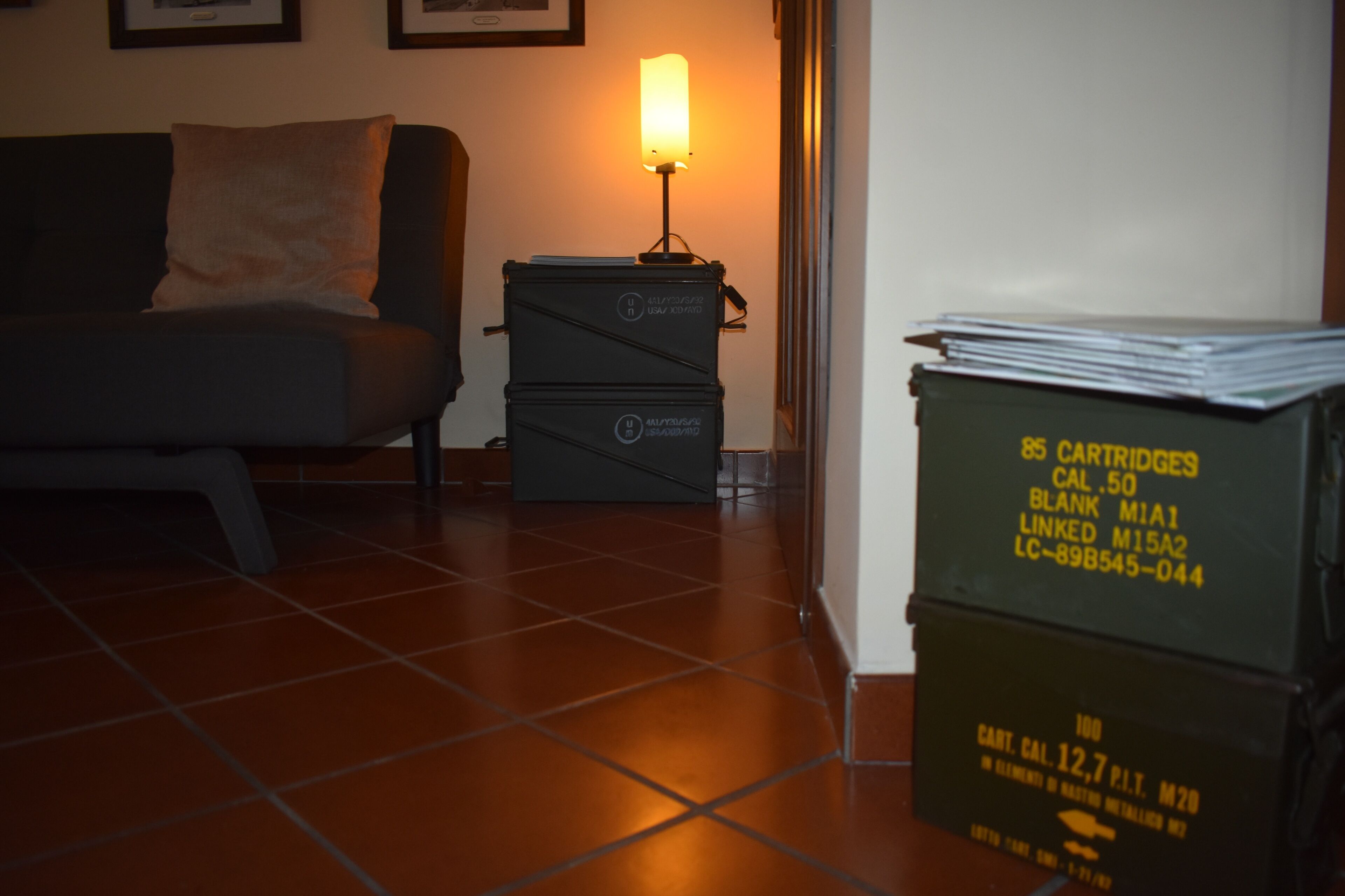 A room with a sofa, a lamp, and storage boxes.
