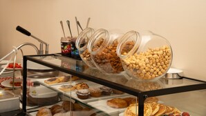 Buffet com diversos alimentos e utensílios.