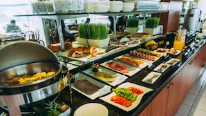 Un bufé con diversas opciones de comida y una estación de café.