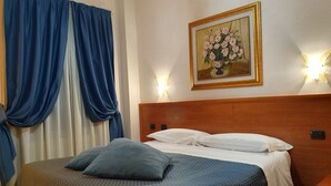 A hotel room with a bed, curtains, a painting, and wall sconces. - Hotel San Giorgio (Bergamo)