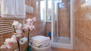 Ein Badezimmer mit Dusche, Toilette und Handtüchern.